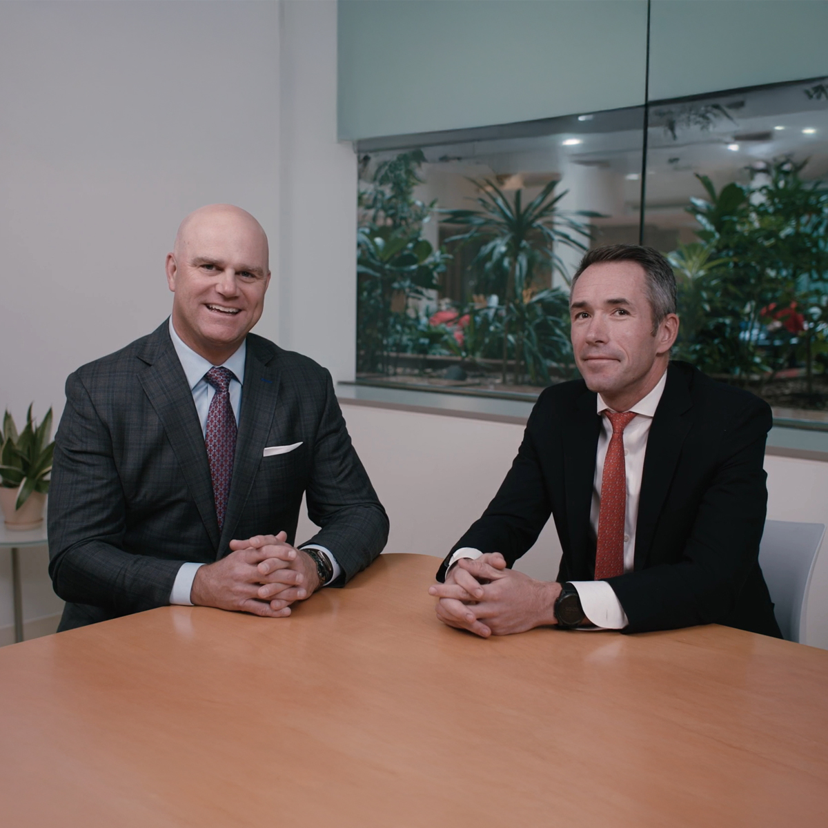 Group of business professionals collaborating in a modern office setting, including men and women in formal attire.