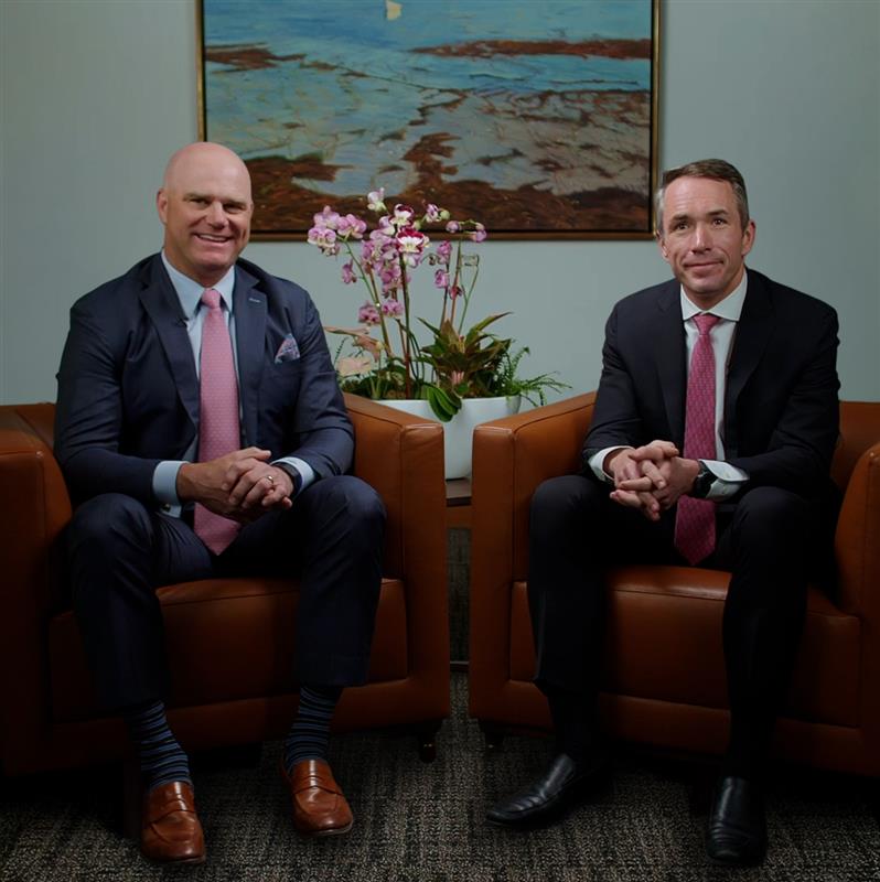 A group of professional businessmen shares a moment of success, reflecting teamwork and positivity in a corporate setting.