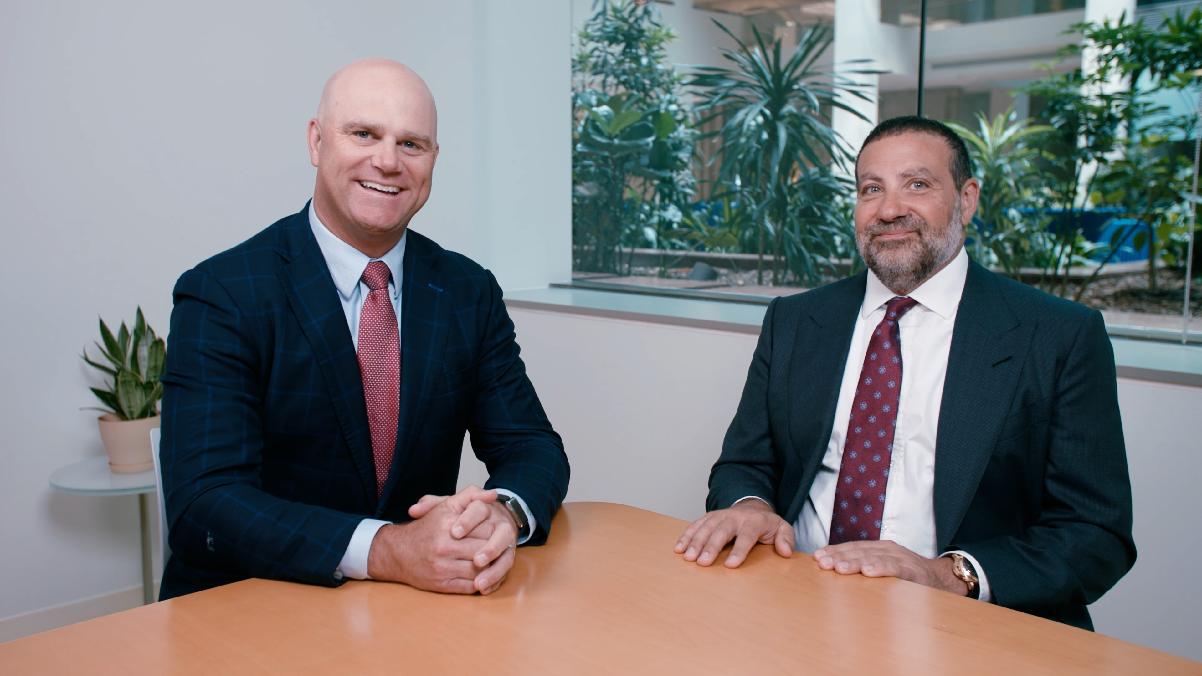 A businesswoman and businessman engage in a professional meeting with their team, fostering collaboration in the office setting.