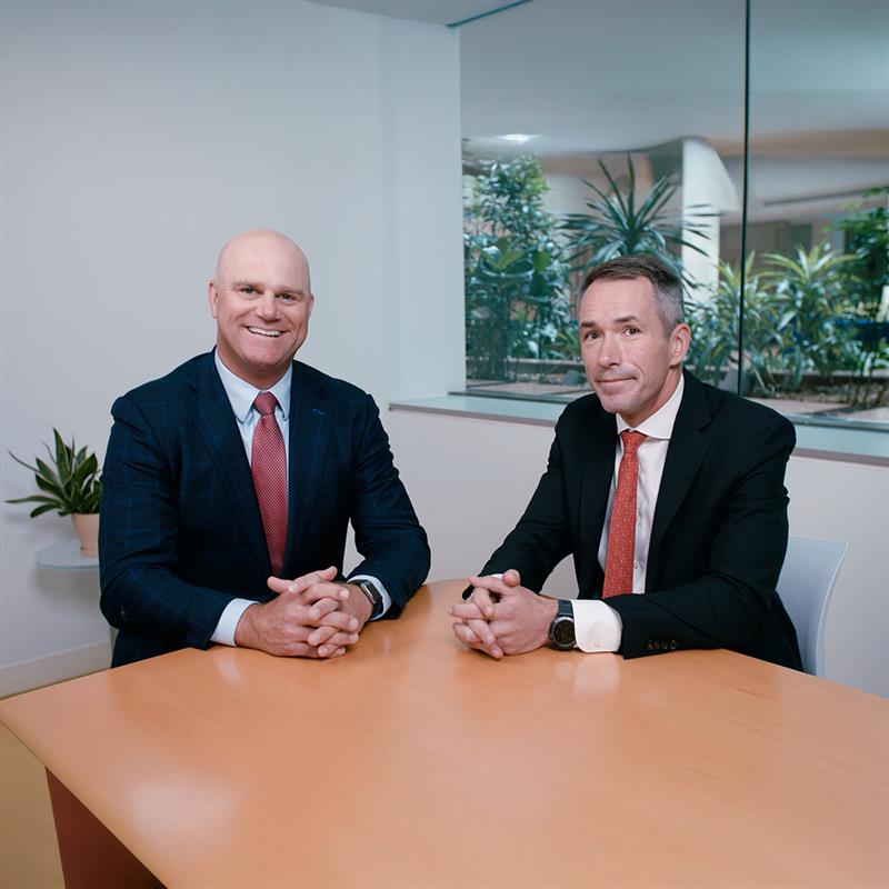 A group of professionals, including businessmen and a businesswoman, collaborate in a modern office setting.