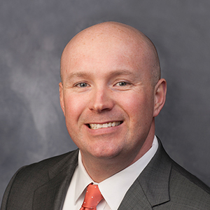 A professional portrait of a confident, happy businessman, showcasing a poised and approachable demeanor.