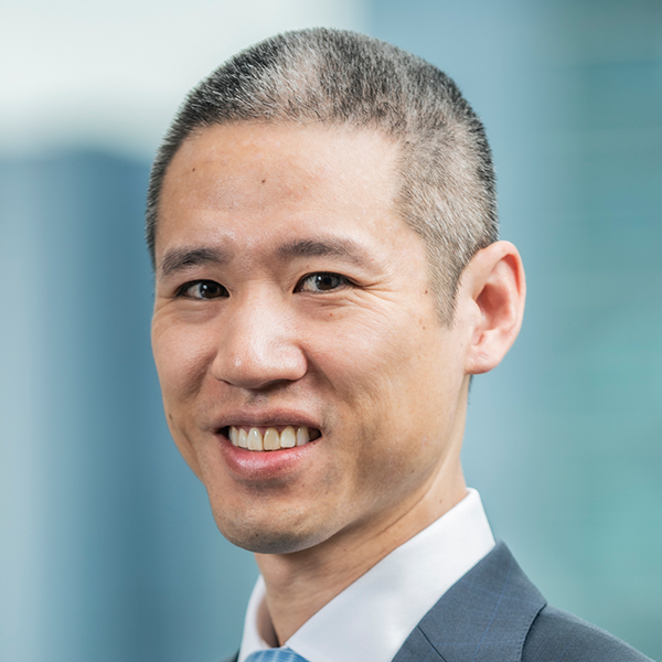 A professional portrait of a young male businessman, showcasing a confident and focused expression in a business setting.