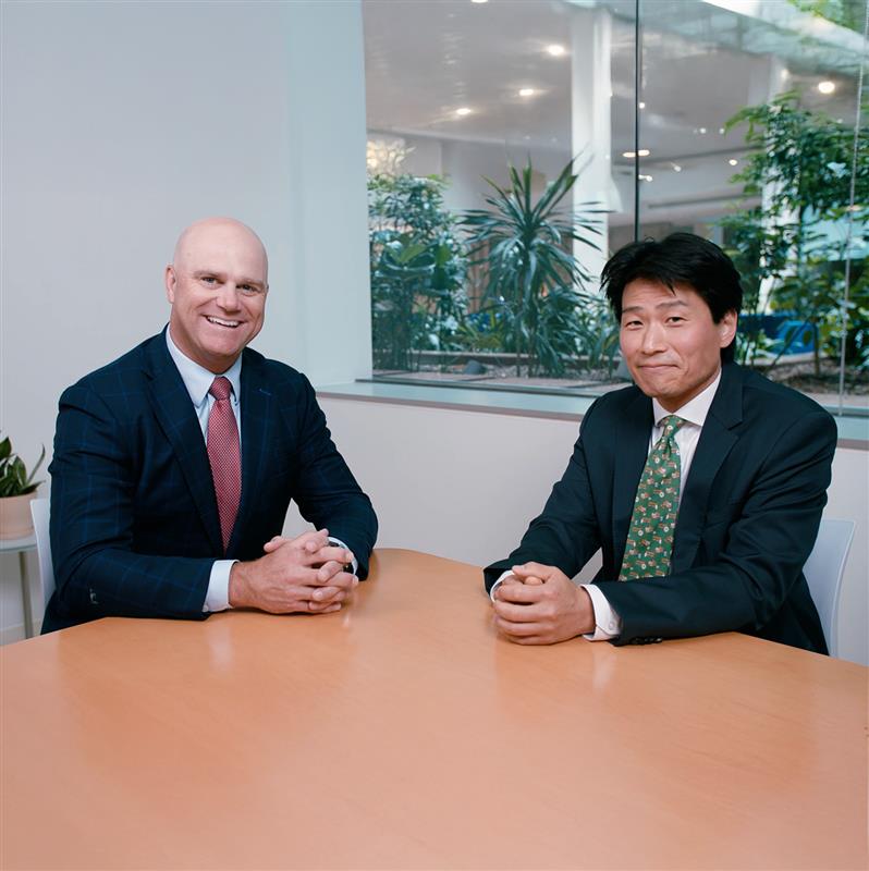 A team of professionals, including a businesswoman and businessman, collaborate during a meeting in a modern office setting.