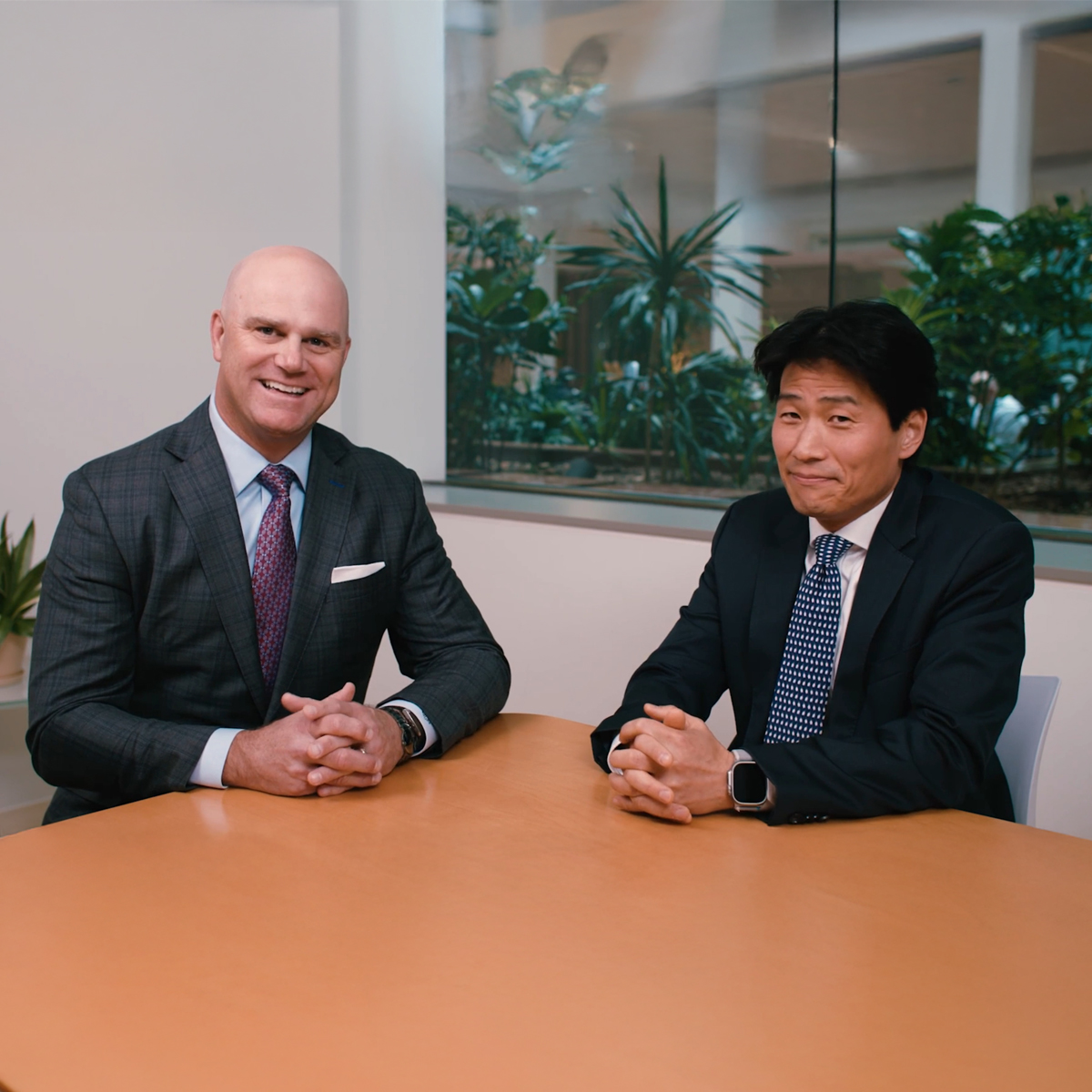 Group of business professionals in formal attire collaborating during a meeting in a modern office setting.