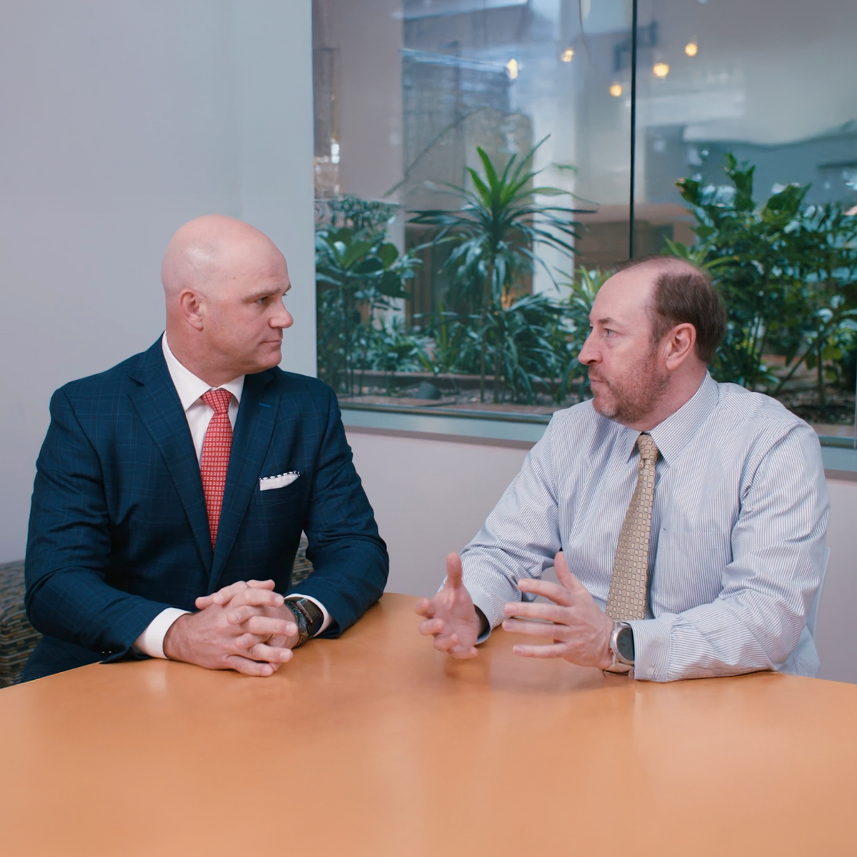 Group of business professionals collaborating in a modern office setting with laptops and documents on a table.