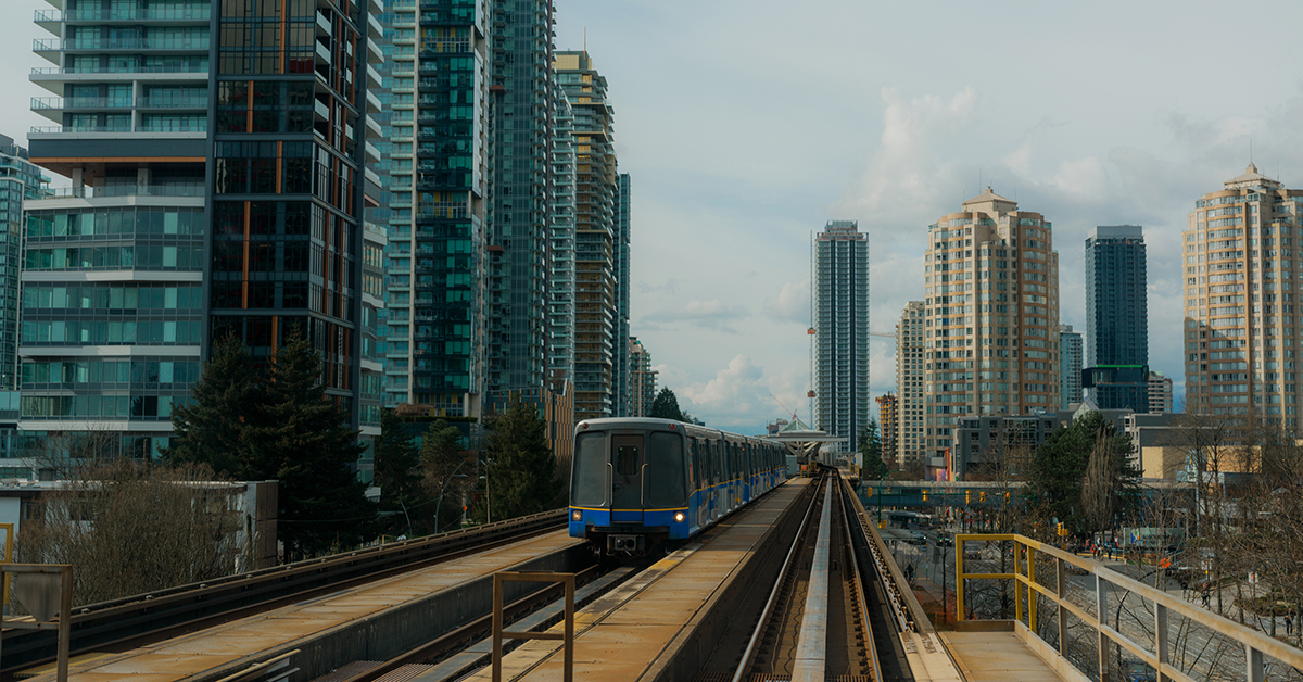 Elevated rail track and train crossing a dense metropolitan skyline, showcasing urban infrastructure and transit corridors.