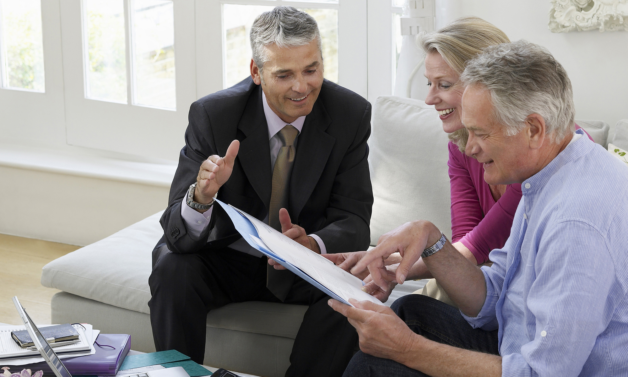 A business man reviews documents with a couple.