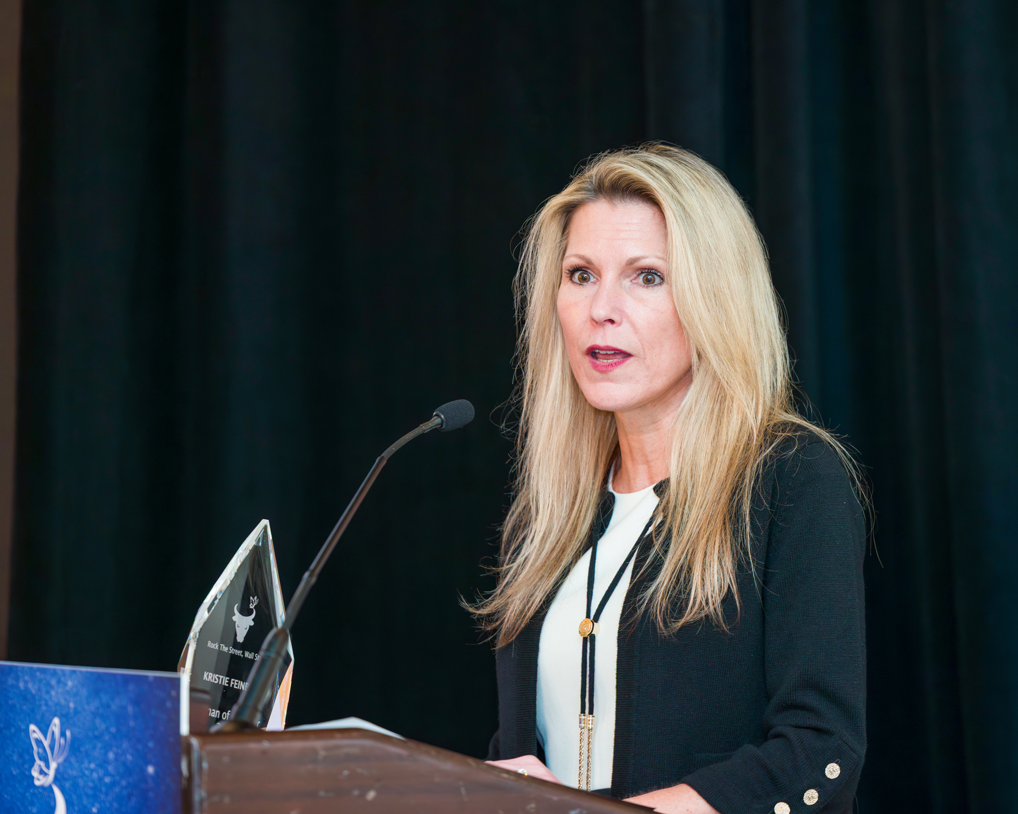Speaker presenting at a podium during a Rock The Street, Wall Street event