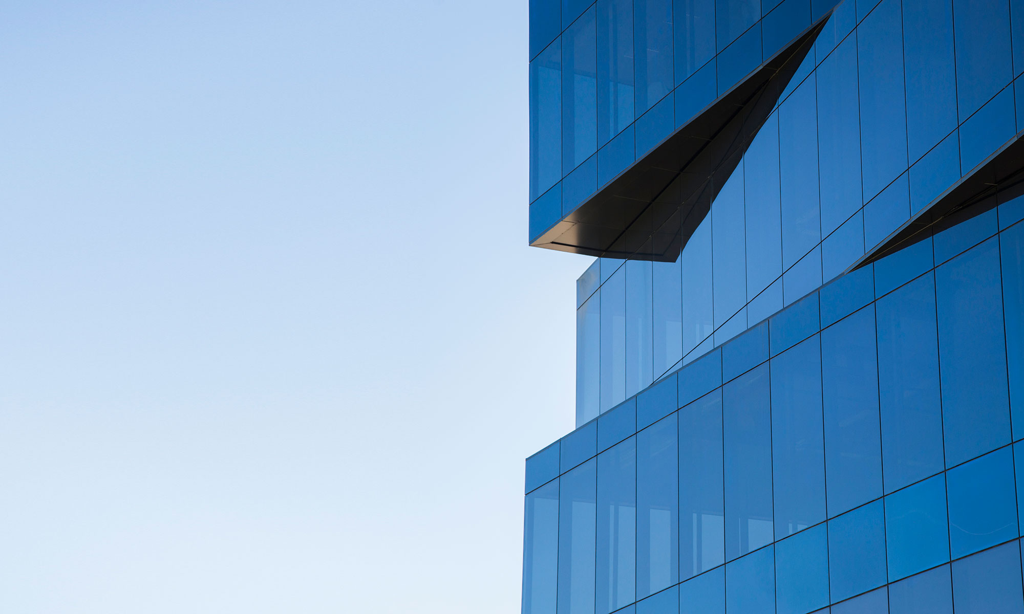 Modern glass office buildings, reflecting the blue sky, showcase urban architectural brilliance in the city.
