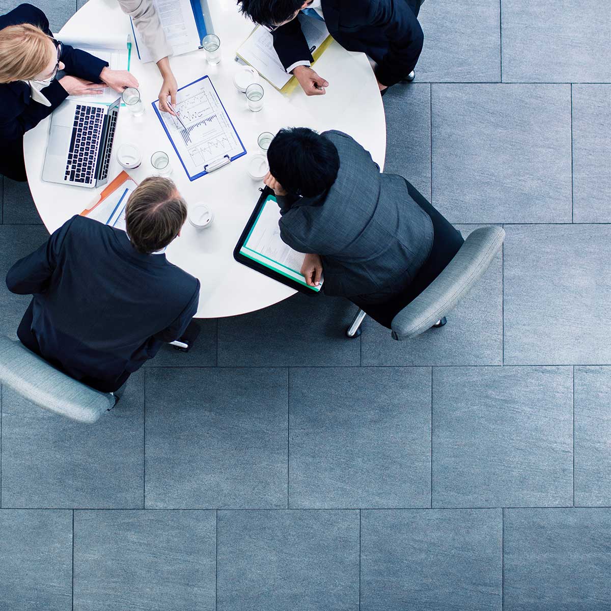 A businesswoman and businessman engage in a professional meeting within a corporate office setting.