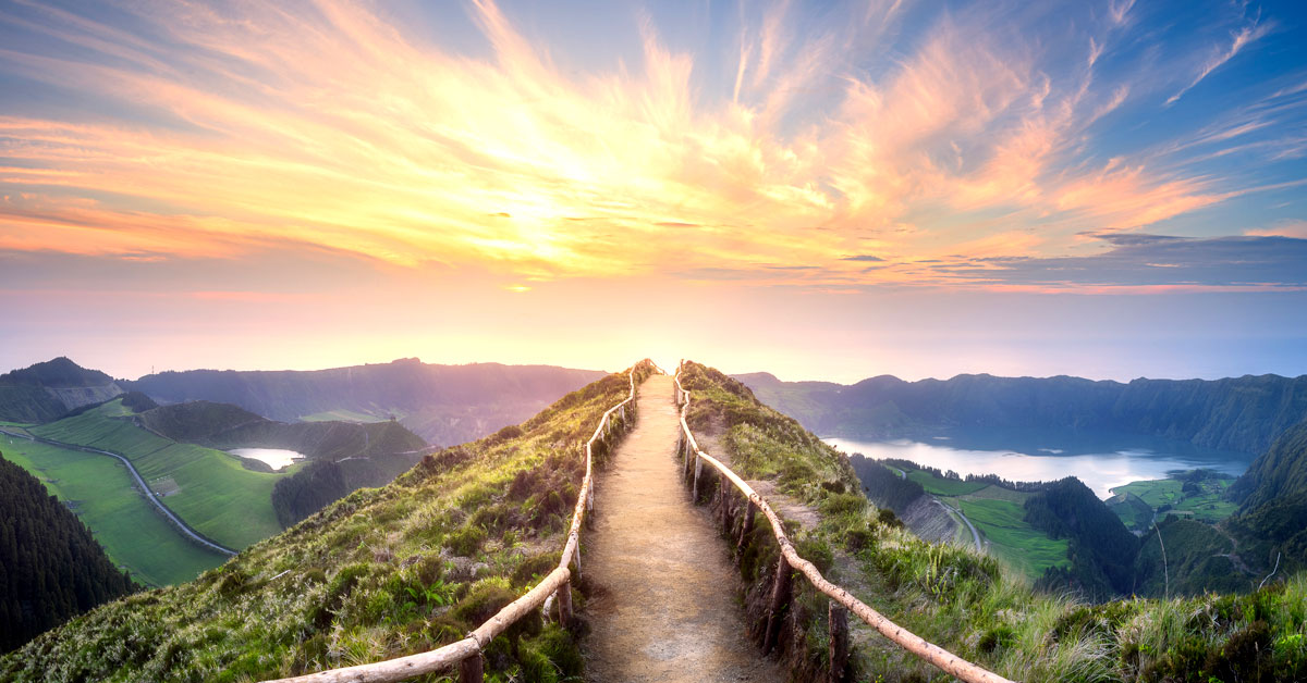 Experience the harmonious blend of nature's green grass, blue sky and sea, along the picturesque coastal road.
